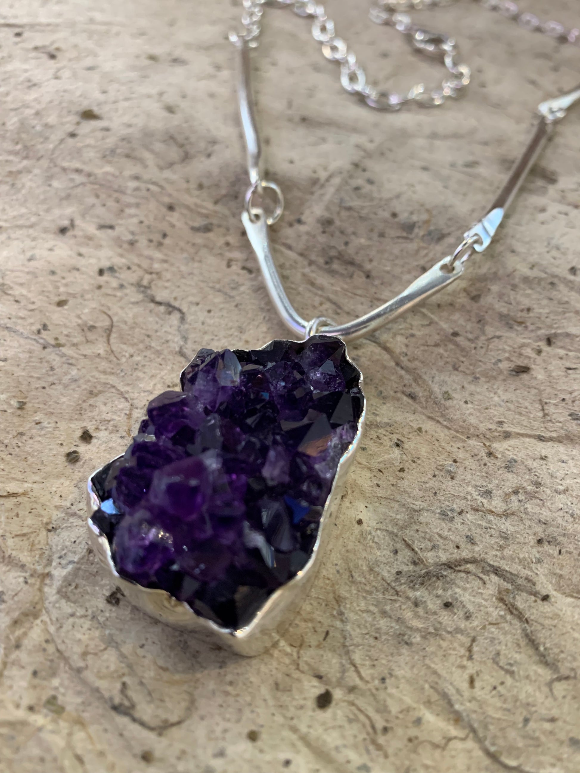 Close up image of a dark purple amethyst cluster sterling silver pendant handmade in Noosa