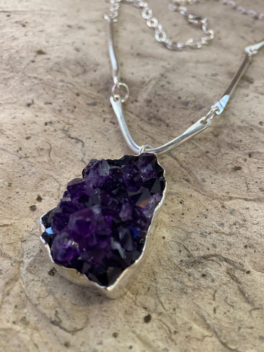 Close up image of a dark purple amethyst cluster sterling silver pendant handmade in Noosa