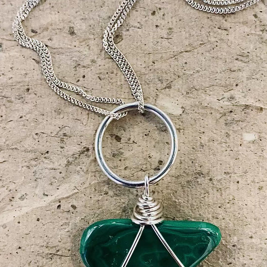 A video showing the natural contours of a large tumble’s slab of malachite set in sterling silver featuring double chains and a hand beaten silver setting 